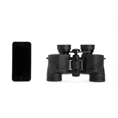 Black binoculars next to a smartphone on a white background