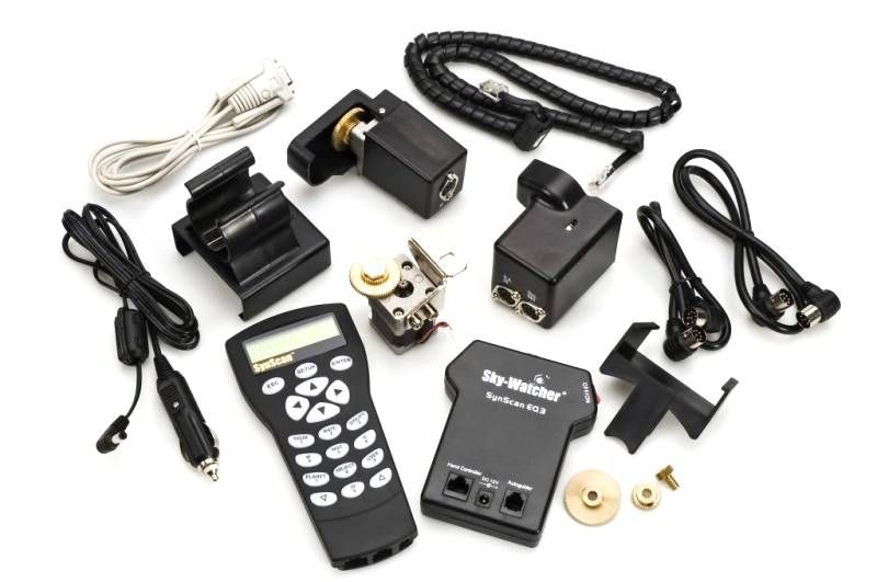 Collection of electronic equipment including a remote control, sensors, and cables on a white background
